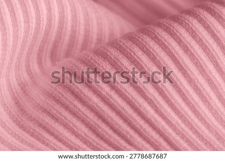 Macro texture of pink knitted wool fabric with ribbed pattern