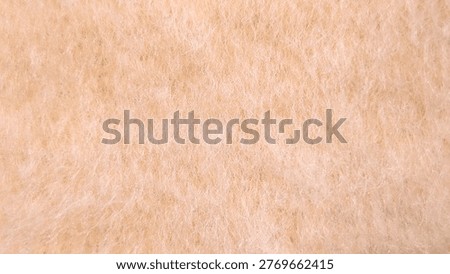 Macro texture of soft fluffy peach-colored wool fleece