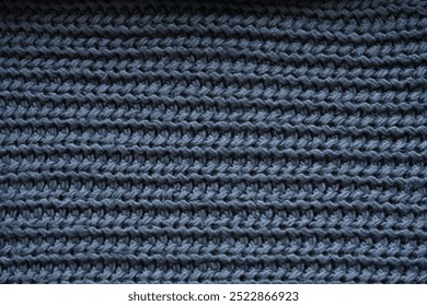 macro texture of woolen dark gray crocheted sweater as background, close-up of gray crocheted front surface, woolen texture of woolen wool, knitted front surface