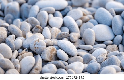 Macro top down composition highlighting the pure aesthetics and smooth powdery textures of completely dry coastal pebbles gathered densely together.