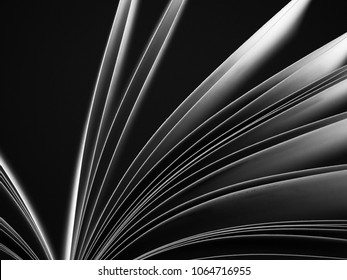 Macro view of book pages. Black and white. Concept of open book, white sheets on dark black  background. Education background. Close-up, selective focus