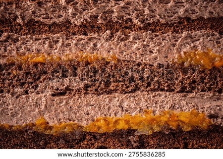 Macro view of chocolate cake layers with airy cream and glossy fruit filling, showcasing rich texture, moisture, and detailed dessert structure.
