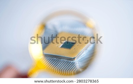 Macro view of computer processor through magnifying glass showing semiconductor chip, CPU architecture and microelectronics. Concept of artificial intelligence, hardware inspection and digital technology.