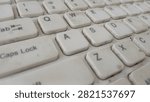 Macro view of dirty white computer keyboard keys showing QWERTY alphabet letters and numbers layout.