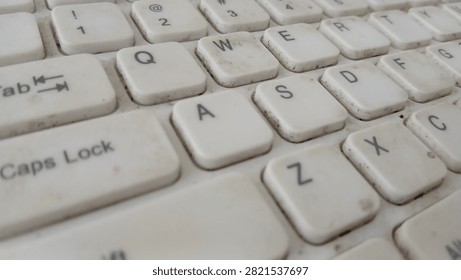 Macro view of dirty white computer keyboard keys showing QWERTY alphabet letters and numbers layout.