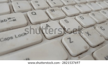 Macro view of dirty white computer keyboard keys showing QWERTY alphabet letters and numbers layout.