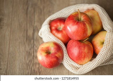 Macro View Of A Group Of Organic Gala Apples In A Reusable Produce Bag On Wooden Table. 