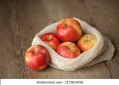 Macro View Of A Group Of Organic Gala Apples In A Reusable Produce Bag On Wooden Table. 