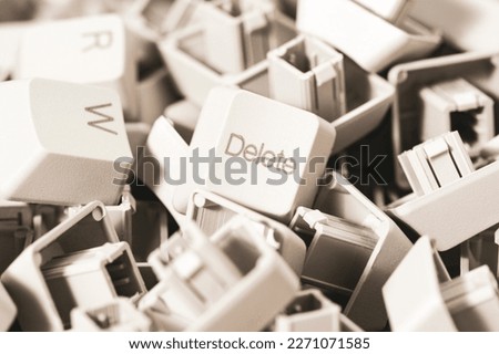 Macro view of a heap of computer keyboard keys. Focus on DELETE key. Computer repair, service.