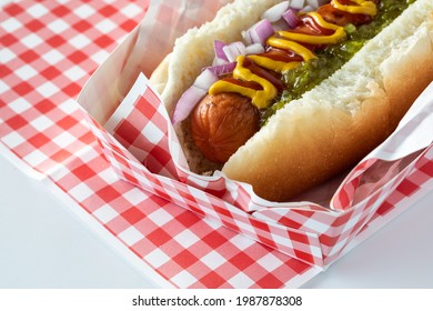 Macro View Of A Hotdog In A Checkered Tray Topped With Mustard, Ketchup And Relish, Ready For Eating.