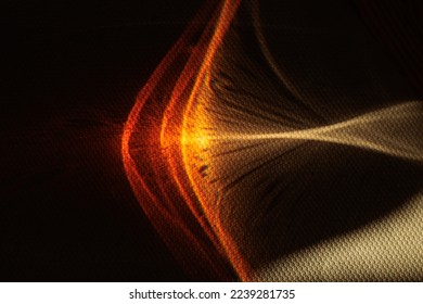 macro view on abstract red, orange, yellow and white reflections being projected on a dark surface through a colored liquid substance inside a glass by the sunlight
