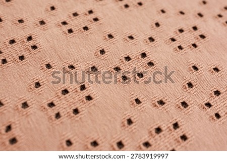 Macro view of soft beige openwork knitted fabric texture