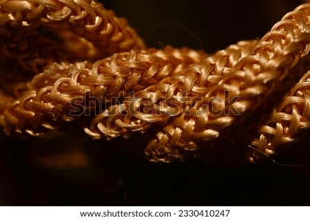 Macro view of threads made of synthetic fibres intertwined on dark background, India.