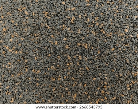 Macro view of tiny pebbles with mixed dark and brown colors, detailed granules texture for surface background and industrial material.