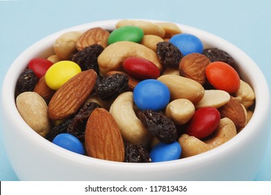 Macro View Of Trail Mix In A White Bowl On Blue Background