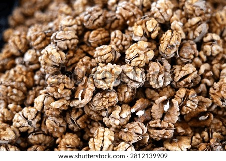 Macro view of whole shelled  walnuts forming a natural textured background. Healthy organic nuts rich in omega-3 fatty acids, perfect for nutrition, food industry and harvest themes.