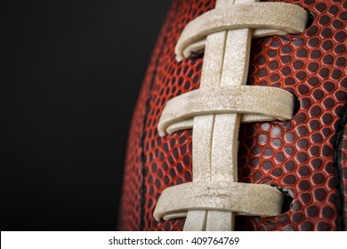 Macro of a vintage worn american football ball with visible laces, stitches and pigskin pattern - Powered by Shutterstock