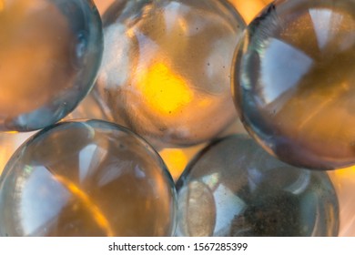 Macrophotography of multicolored glass, shiny balls on a luminous background, bokeh, balls glow from the inside, blurred circles, lights. Ball, pattern, background blur, holiday fireflies, space, boke
