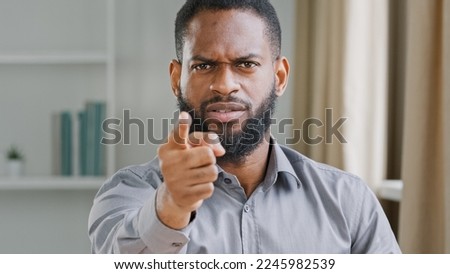 Mad angry aggressive bearded African American businessman professional HR manager employer man office worker pointing finger at camera work threat warning promise dismissal hey you bad work reaction