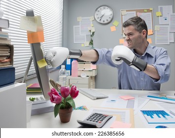 Mad Angry Office Worker Punching Computer With Boxing Gloves.