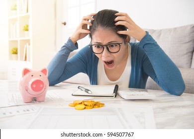 Mad Asian House Woman Feel Crazy To See Less Money Pour Out From Piggy Bank No Enough To Pay Expenditure Sitting On Sofa In The Living Room At Home. Interior And Domestic Housework.