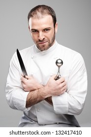 Mad Chef Holding Kitchen Tools in a Grey Background