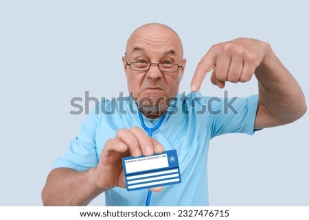 mad doctor holds electronic public health insurance cheaper, Insurance Card, elderly physician with an expressive facial expressions aggressively shows European health insurance card, healthcare cost