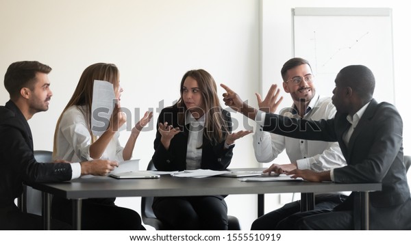Mad frustrated multiethnic employees sit at
office meeting dispute quarrel have stressful job situation, angry
diverse colleagues debate fight over paperwork financial
statistics, work stress
concept