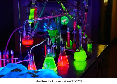 Mad Scientist Chemistry Lab In Dark With Glowing Green And Red Chemicals