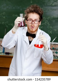 Mad Scientist Shows Two Flasks With Colored Liquid In His Laboratory