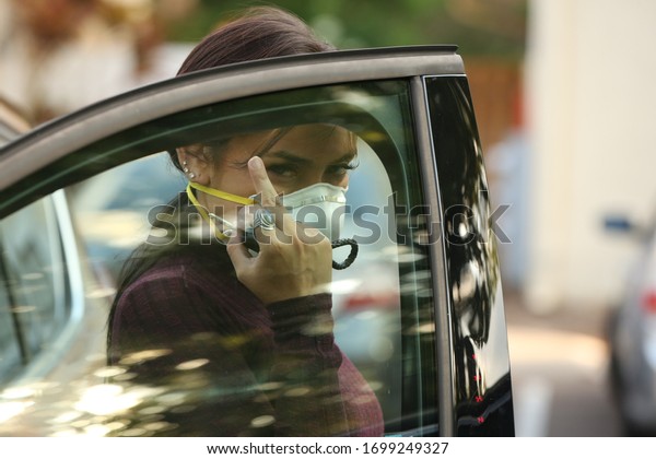 mad woman\
getting out of car wearing a medical\
mask