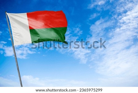 Madagascar Flag - The captivating flag of Madagascar waving gracefully. This flag features two horizontal bands of red and white, with a vertical green band on the hoist side