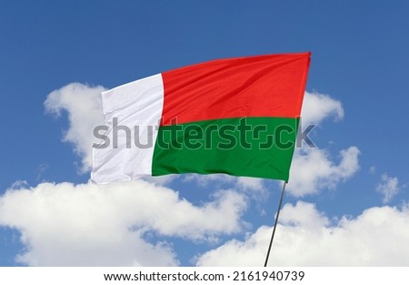 Madagascar flag is isolated on the blue sky with a clipping path. flag symbols of Madagascar.