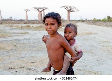 Madagascar-shy And Poor African Girl With Infant On Her Back - Poverty