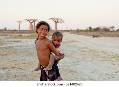 Madagascar-shy And Poor African Girl With Infant On Her Back - Poverty