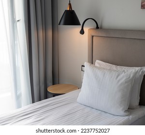 Made up bed in a hotel room with night lamps - Shutterstock ID 2237752027