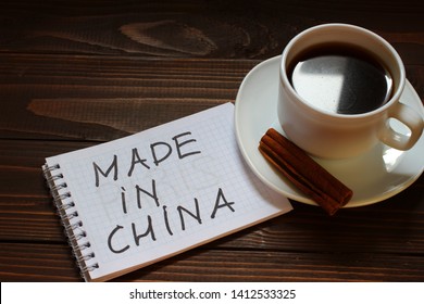 Made in china inscription and word in a notebook near a cup of coffee