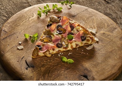 Made From Re-Plated Waste - Fresh Pizza Slice With Mushrooms, Olives, Meat, Cheese, Herbs On Wood Board, Wood Table, Angled View