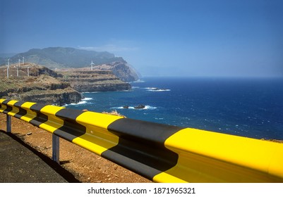 Madeira cliff with wind turbines and guard rail