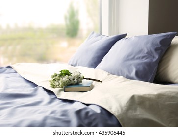 Made-up Bed With Blue Bed Linens And Book