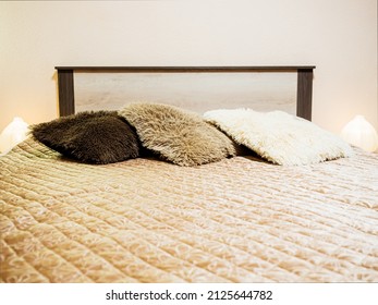 A Made-up Bed With Fluffy Pillows And A Quilted Bedspread. Soft Focus