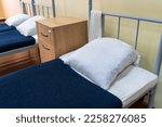 The made-up bed of a soldier in the barracks. Background with selective focus