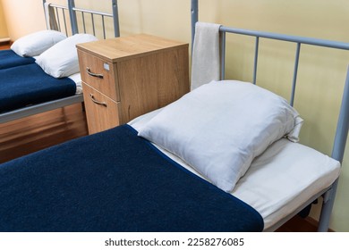 The made-up bed of a soldier in the barracks. Background with selective focus