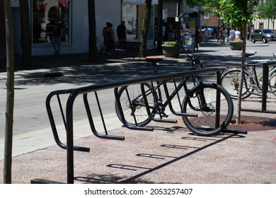 Madison, Wisconsin, United States Of America - June 19, 2021: A Bicycle Parked In A Bike Holder On The Sidewalk With Copy Space