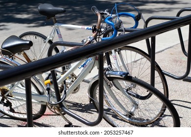 Madison, Wisconsin, United States Of America - June 19, 2021: Bicycles Parked In A Bike Holder On The Sidewalk