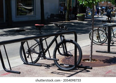 Madison, Wisconsin, United States Of America - June 19, 2021: A Bicycle Parked In A Bike Holder On The Sidewalk