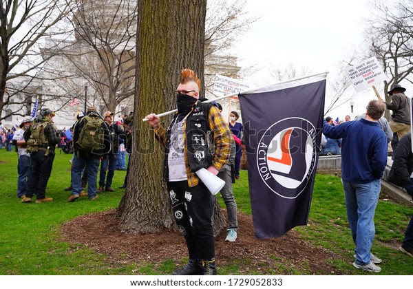 Madison, Wisconsin / USA - April 24th, 2020: Antifa member protests against the stay at home order protesters during the reopen Wisconsin rally during the covid-19 outbreak pandemic