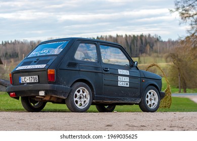 Madona, Latvia - May 01, 2021: colorful oldtimer PanCars rental car Fiat 126 parked on the side of a country road