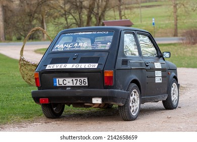 Madona, Latvia - May 01, 2021: colorful oldtimer PanCars rental car Fiat 126 parked on the side of a country road