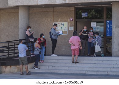 Madrid / Spain - 06/18/2020: Group of people waiting outside in public building. New situation in Spain about the pandemic of Covid-19. People are using mask in their new life routine. 